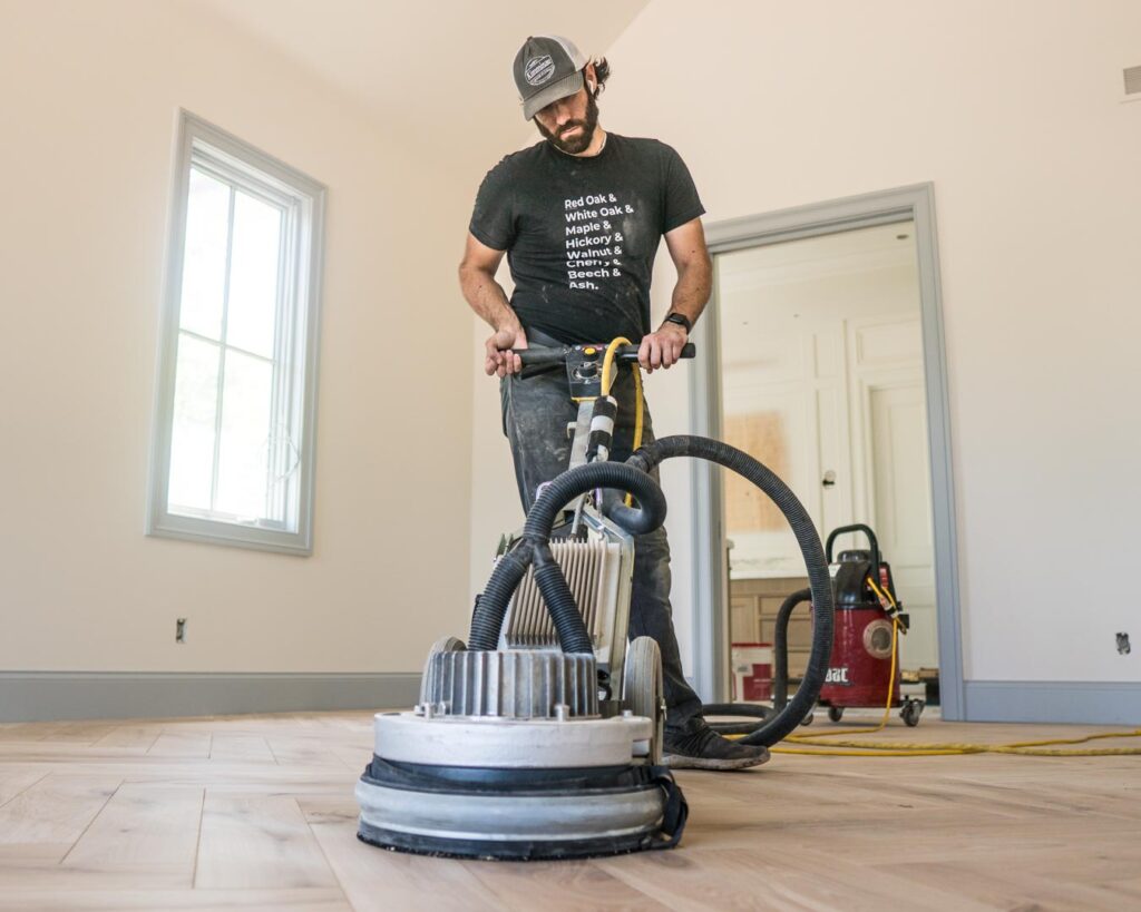 Man refinishing wood flooring.