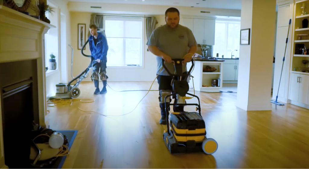 Flooring team applying maintenance coat to wood floors.